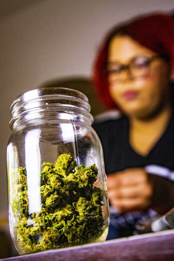 Cannabis flower displayed in a jar at a dispensary counter